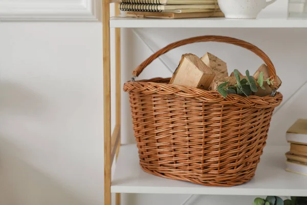 Rafta odun dolu sepet, ışık duvarının yanında.