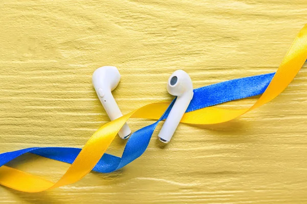 Earphones Ribbons Colors Ukrainian Flag Yellow Wooden Background — Stock Photo, Image
