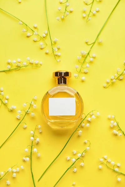 色の背景に香水とユリの谷の花のボトル — ストック写真