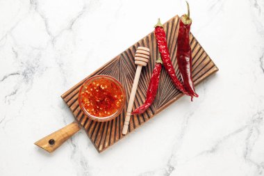 Açık arkaplanda sıcak bal ve kuru kırmızı biberli pano