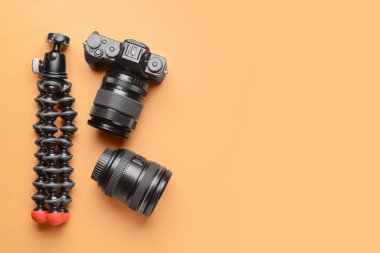 Renk arkaplanında dijital kamera, lens ve tripod