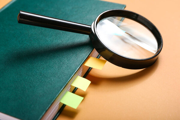 Книга с закладками и лупой на цветном фоне