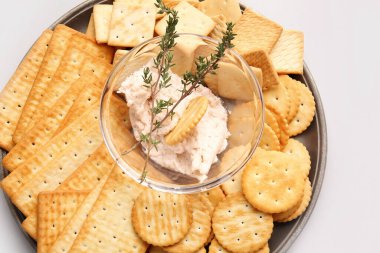 Gri arka planda lezzetli kraker ve sos tabağı, yakın plan.