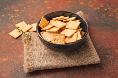 Grunge arka planında lezzetli krakerler olan kase