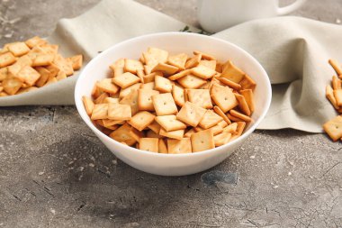 Grunge arka planında lezzetli krakerler olan kase