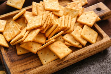 Masada lezzetli krakerler olan tahta, yakın plan.