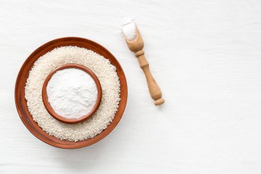 Çiğ pirinçli kaseler ve ahşap zemin üzerinde un.