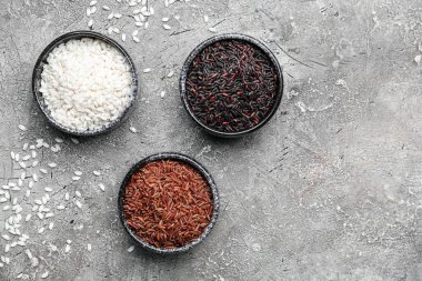 Grunge arka planında farklı tipte çiğ pirinç olan kaseler