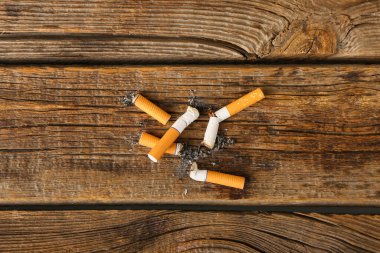 Ahşap arka planda sigara izmaritleri