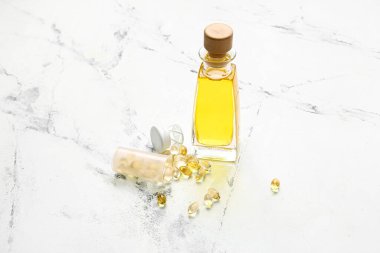 Açık arkaplanda balık yağı ve kapsüller.