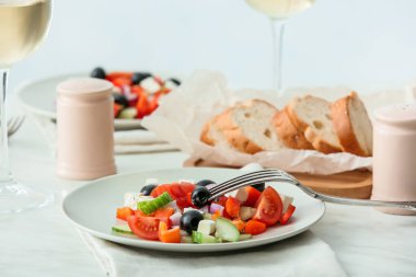 Restorandaki masada taze Yunan salatası tabakları.