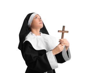 Gri arka planda haçı olan olgun bir rahibe.