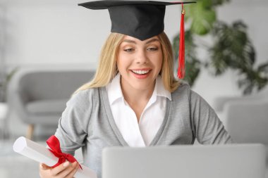 Mezuniyet gününde evde mutlu bir bayan öğrenci. Çevrimiçi eğitim kavramı