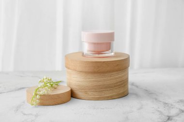 Krema kavanozu ve açık arkaplanda çiçekleri.