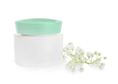 Krema kavanozu ve beyaz arka planda zambak çiçeği.