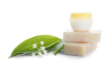 Krema kavanozu, sabun ve beyaz arka planda zambak.