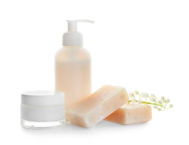 Kozmetik ürünleri ve beyaz arka planda çiçekleri.