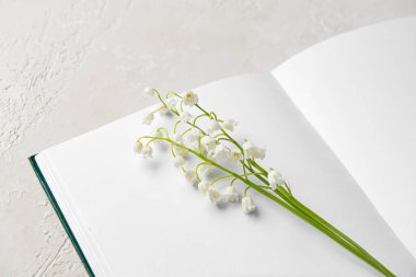 Boş bir kitap ve arka planda güzel bir zambak, yakın plan.