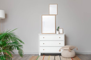 Çekmeceli ve boş fotoğraf çerçeveli modern stil bir oda.