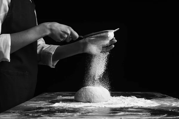黒地に小麦粉をふるいにかける女 — ストック写真