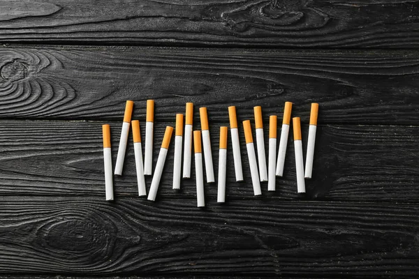 深色木制背景下的香烟 — 图库照片