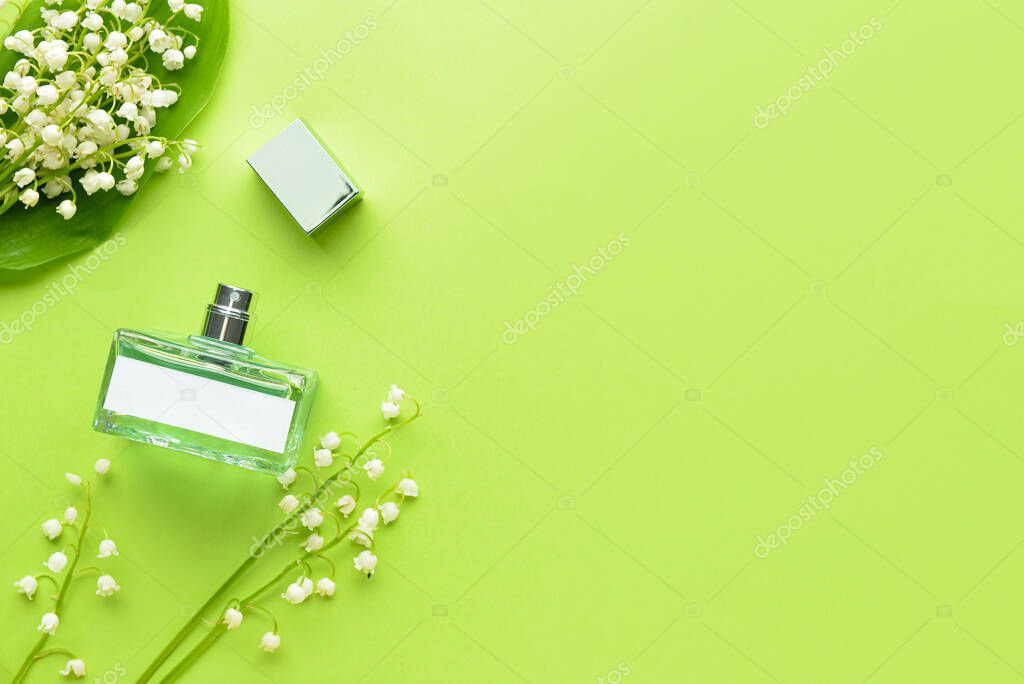 Bottle of perfume and lily-of-the-valley flowers on color background