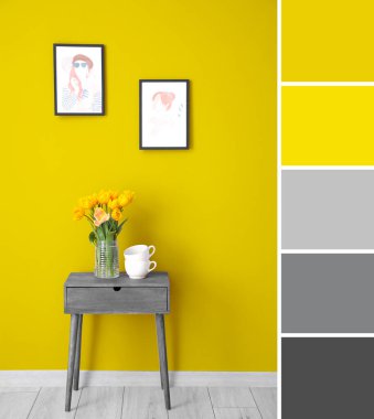 Sarı duvarın yanındaki gri masada lale çiçekleri ve fincanlar. Farklı renk desenleri