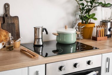 Mutfaktaki elektrikli ocakta demlik ve kahve makinesi.