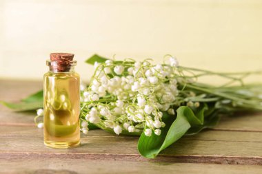 Kaliteli yağ şişesi ve ahşap arka planda zambak çiçeği.