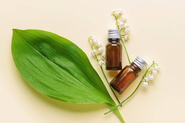 Gerekli yağlı şişeler ve arka planda zambak çiçekleri.