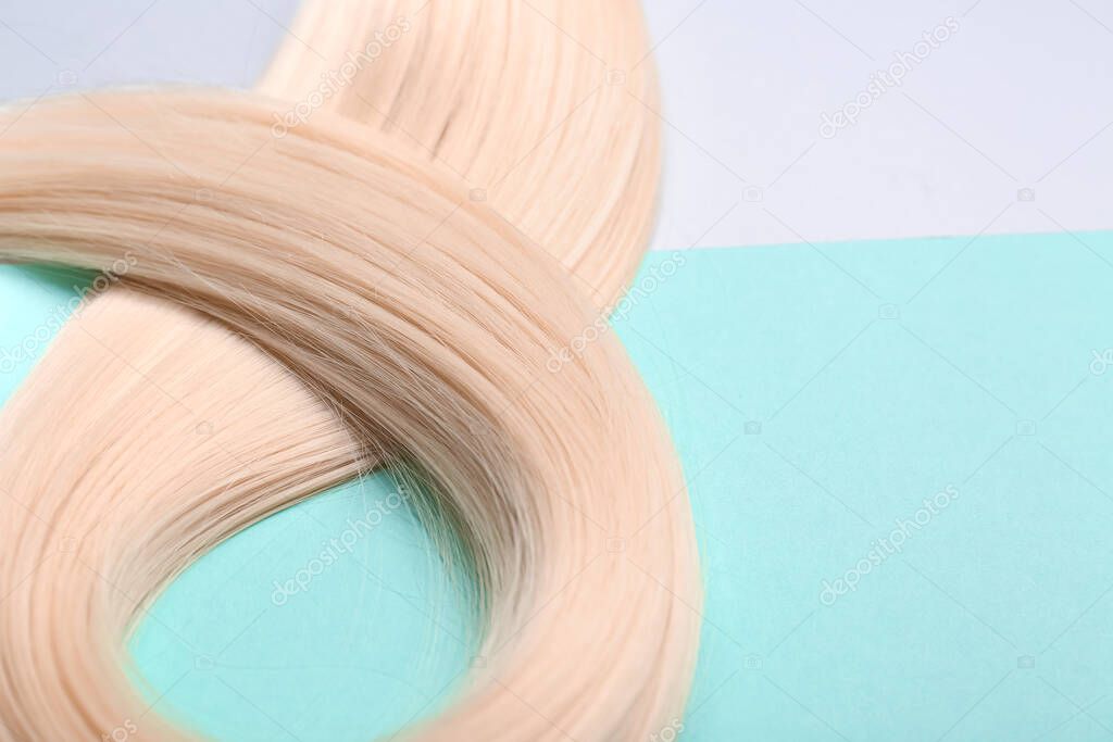 Blonde hair on color background, closeup