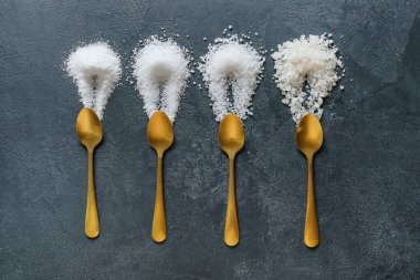 Koyu arkaplanda farklı tuzlu kaşıklar