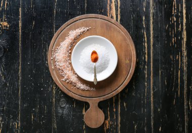 Koyu ahşap arka planda farklı tuz içeren kompozisyon