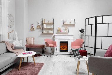 Modern oturma odası, şömine ve dizüstü bilgisayarlı.