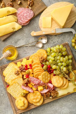 Peynirli lezzetli krakerler ve gri arka planda atıştırmalıklar.