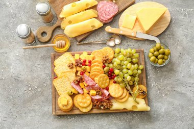 Peynirli lezzetli krakerler ve gri arka planda atıştırmalıklar.