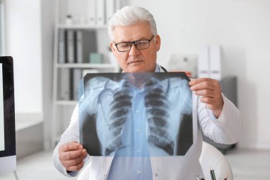 Pulmonologist with x-ray image of lungs in clinic clipart