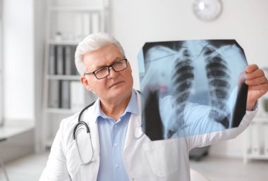 Pulmonologist with x-ray image of lungs in clinic clipart