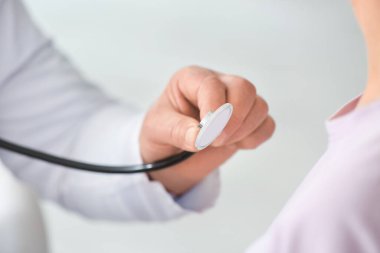 Steteskoplu akciğer uzmanı klinikteki hastayı muayene ediyor.