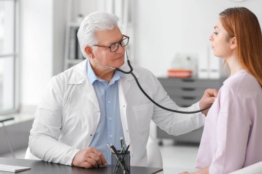 Steteskoplu akciğer uzmanı klinikteki hastayı muayene ediyor.