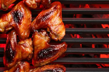 Izgarada pişen kızarmış tavuk kanatları.