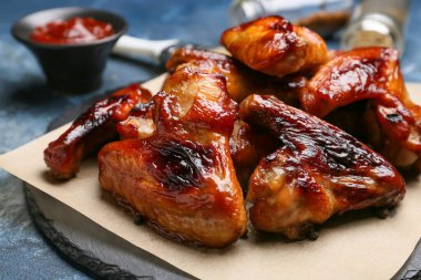 Renkli arka planda kızarmış tavuk kanatları olan tahta