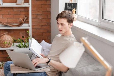 Genç adam evde online çalışıyor.