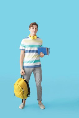 Renk arkaplanı kitapları olan erkek öğrenci