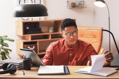 Genç Afro-Amerikalı çocuk evde online çalışıyor.