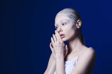 Renkli kaşları ve aksesuarları olan güzel bir genç kadın.