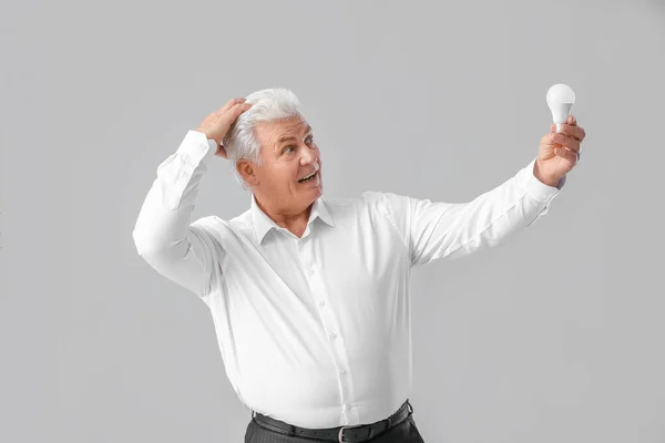 Uomo Affari Anziano Con Lampadina Sfondo Grigio Concetto Idea — Foto Stock