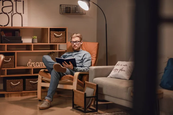 Joven Leyendo Libro Mientras Está Sentado Sillón Casa — Foto de Stock