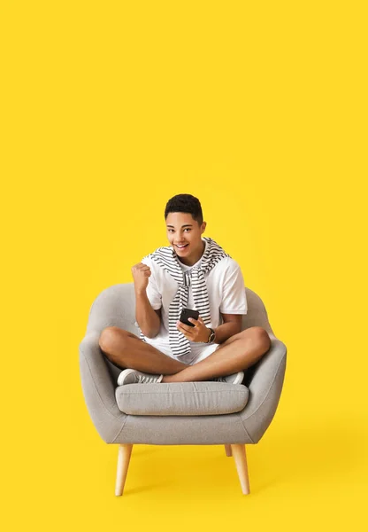 Happy African American Guy Phone Sitting Armchair Color Background — Stock Photo, Image
