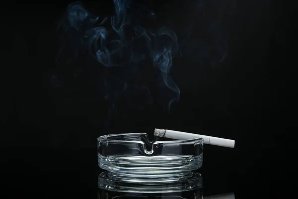 暗い背景にタバコと灰盆 — ストック写真